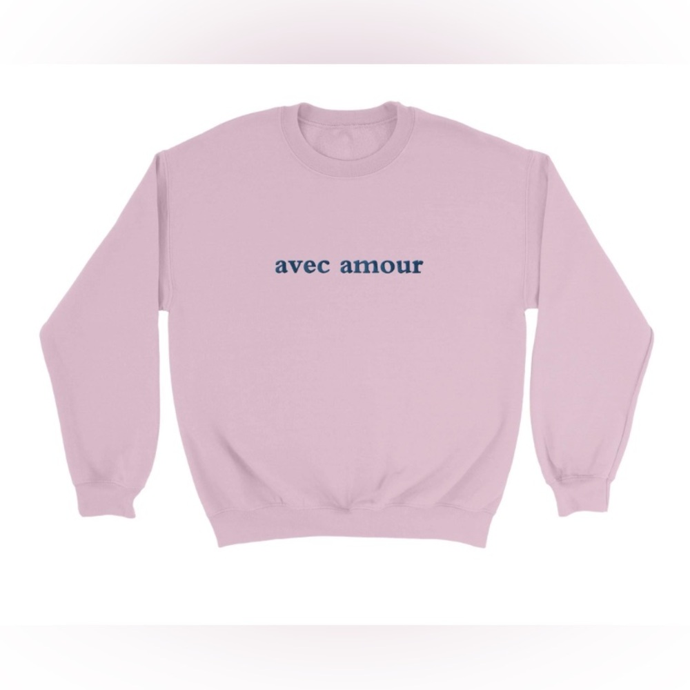 Pink crewneck sweater embroidered with the phrase “Avec amour” meaning with love